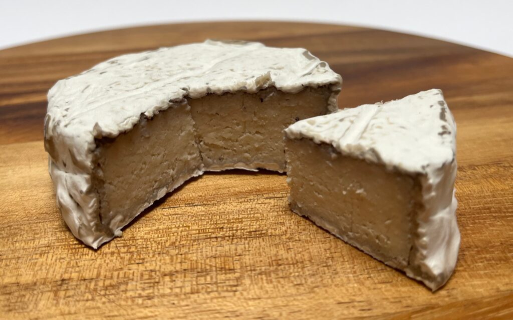 Camelia vegan cheese by Casa del fermentino with a wedge cut out