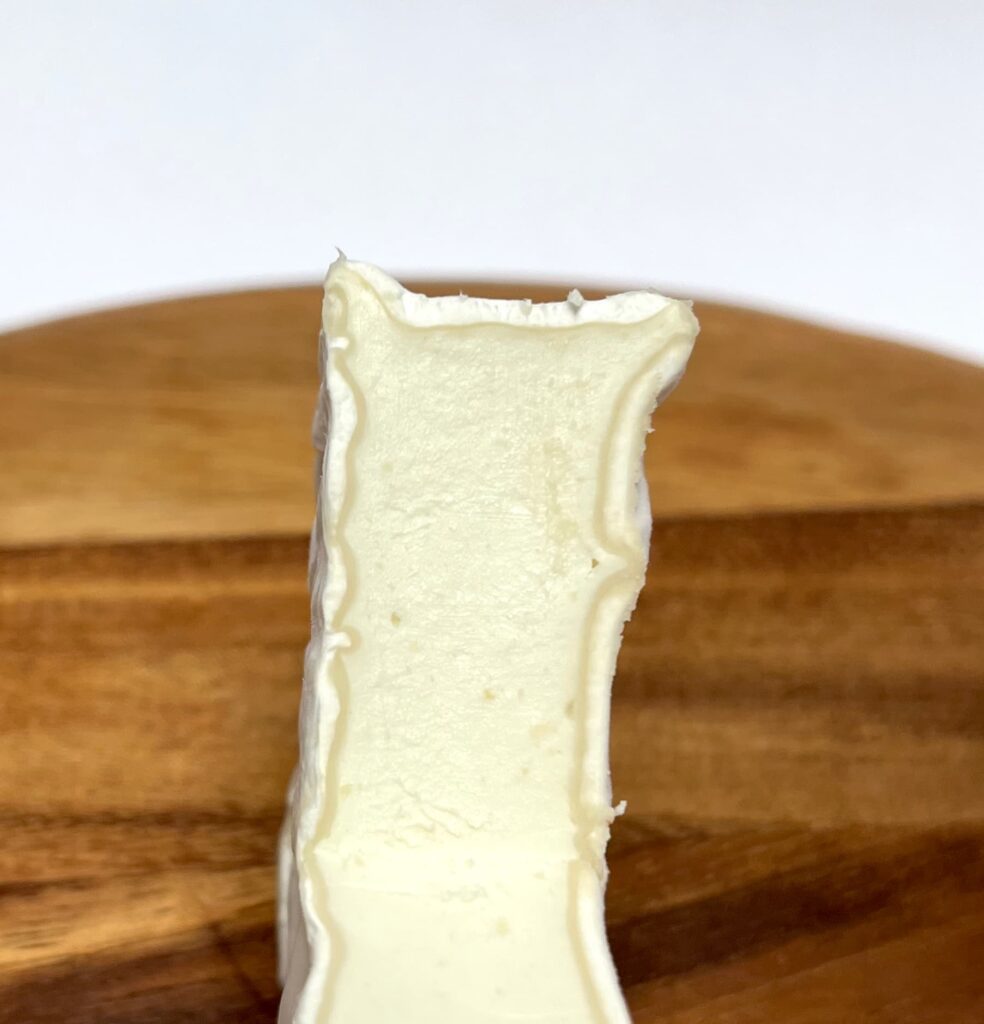 Soft White vegan cheese by Mondarella with intersection cut