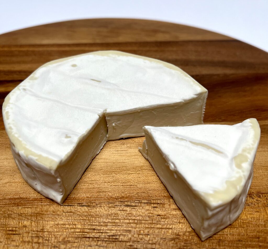 Soft White vegan cheese by Mondarella with a wedge cut out