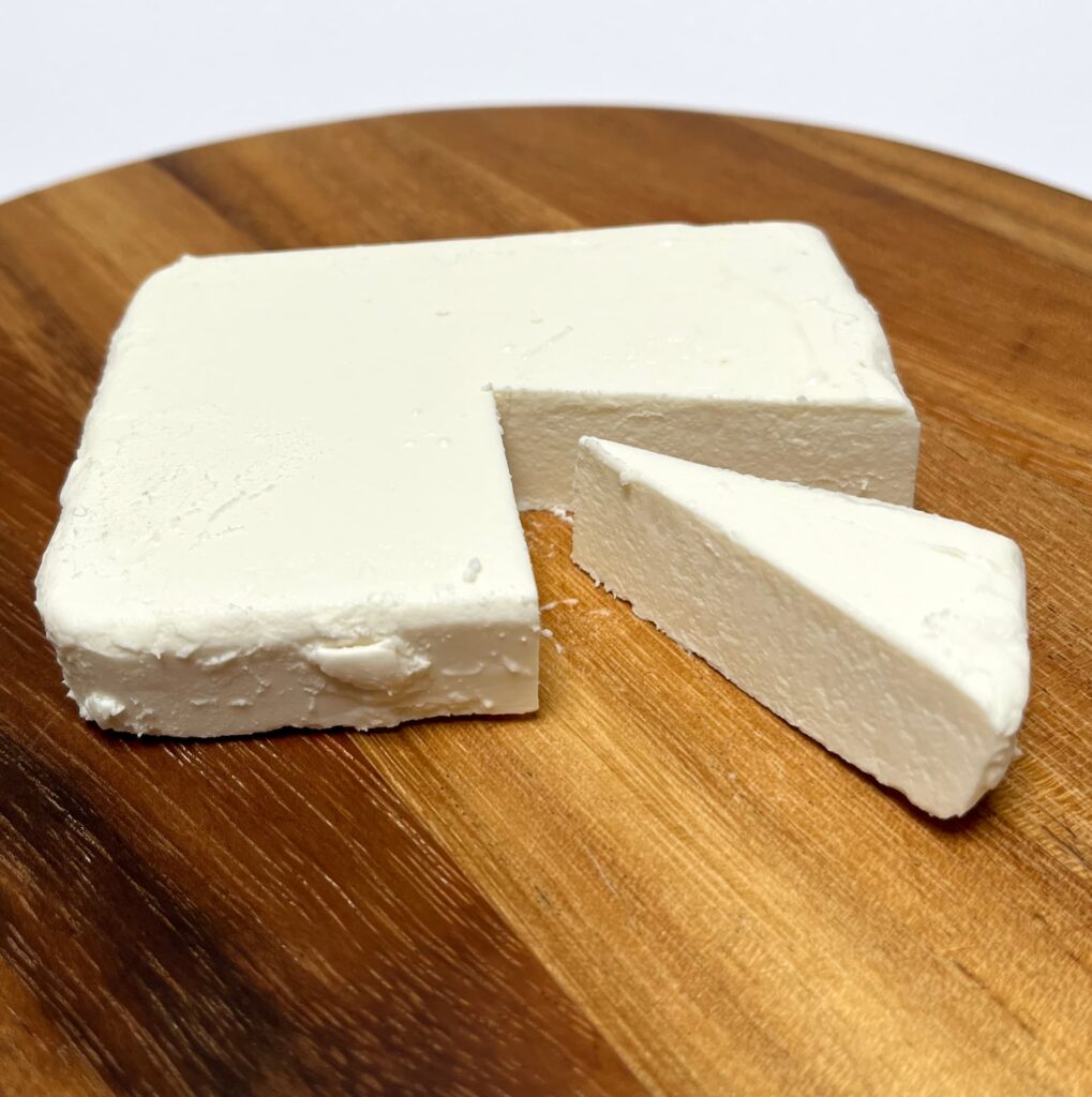 Feta-like vegan cheese by Simply-V with a wedge cut out