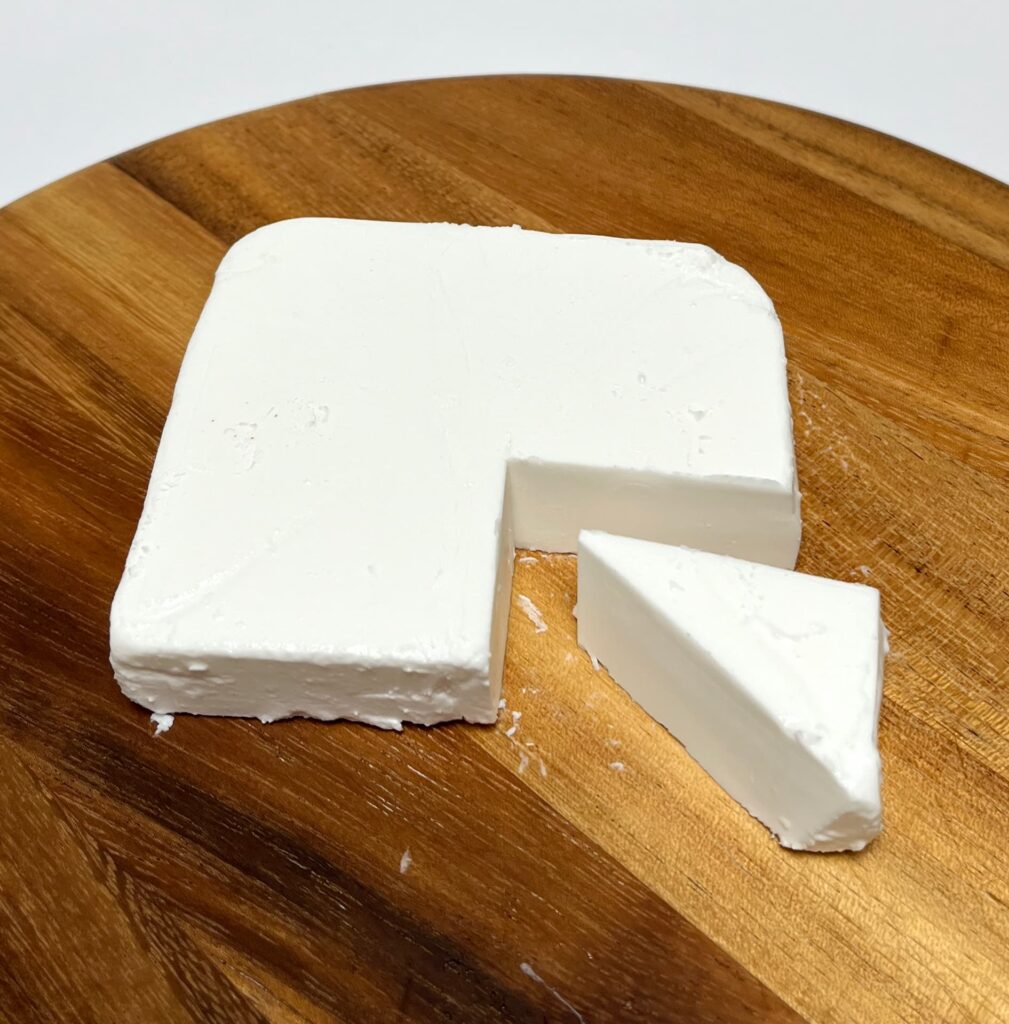 Greek white vegan cheese by Violife with a wedge cut out