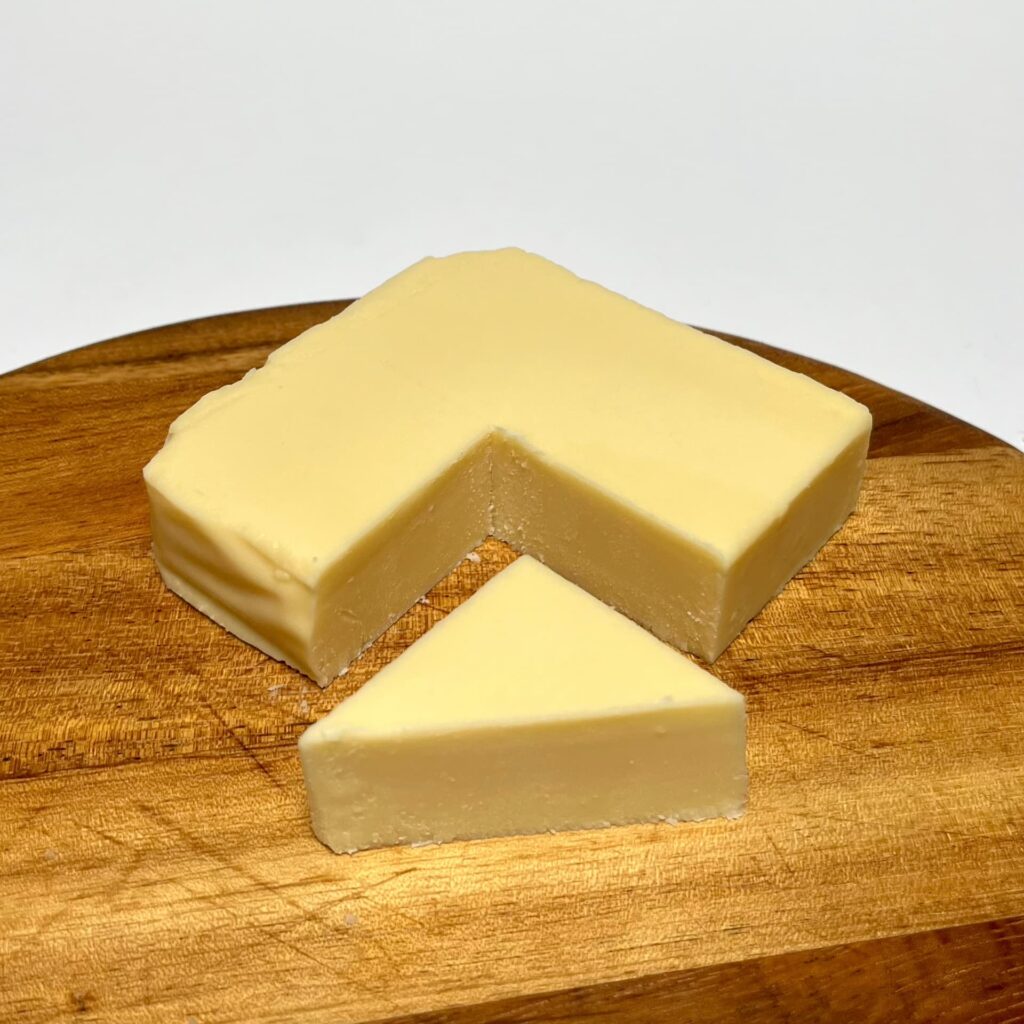 Cheddarton vegan cheeese by Violife with a wedge cut out