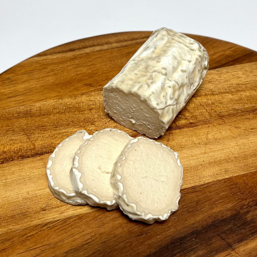 Simply G.O.A.T vegan cheese by Nutty Artisan Foods with slices cut off